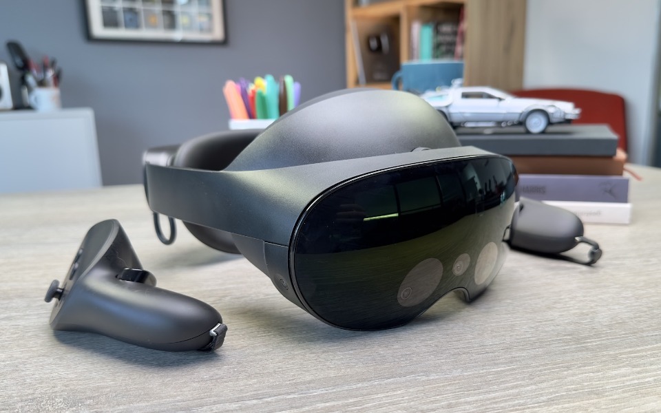 
        Nowoczesne gogle VR leżące na biurku z akcesoriami.
    