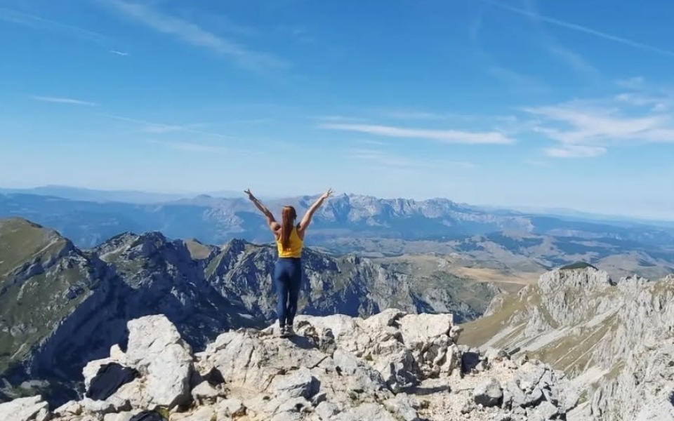 
        Osoba na szczycie góry, ciesząca się pięknym widokiem.
    