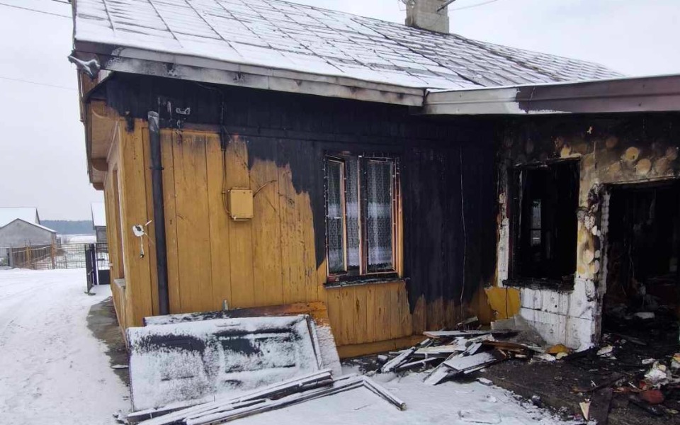 
        Zniszczony dom po pożarze, z widocznymi śladami spalenizny.
    