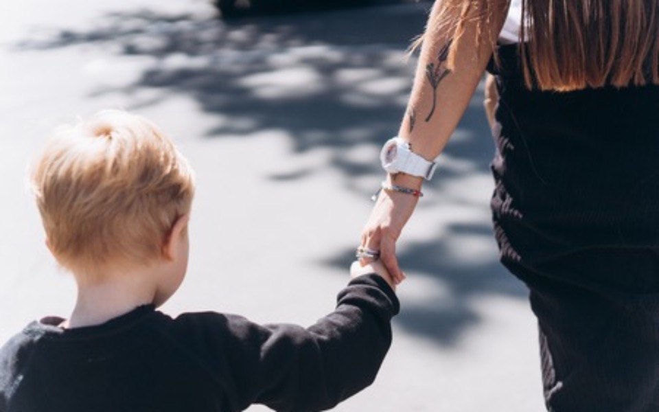 
        Dziecko trzymające się za rękę z dorosłym.
    