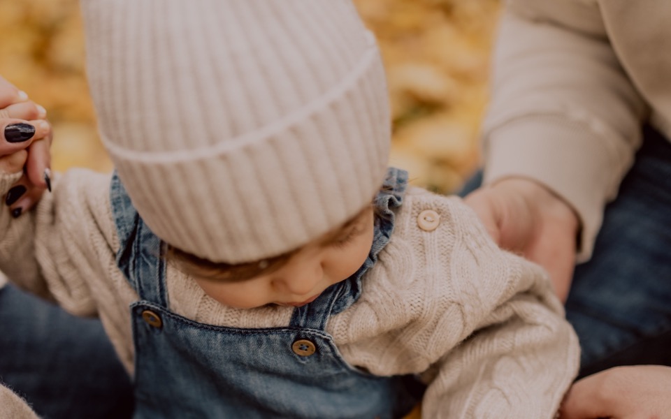 
        Małe dziecko w ciepłym swetrze i czapce.
    