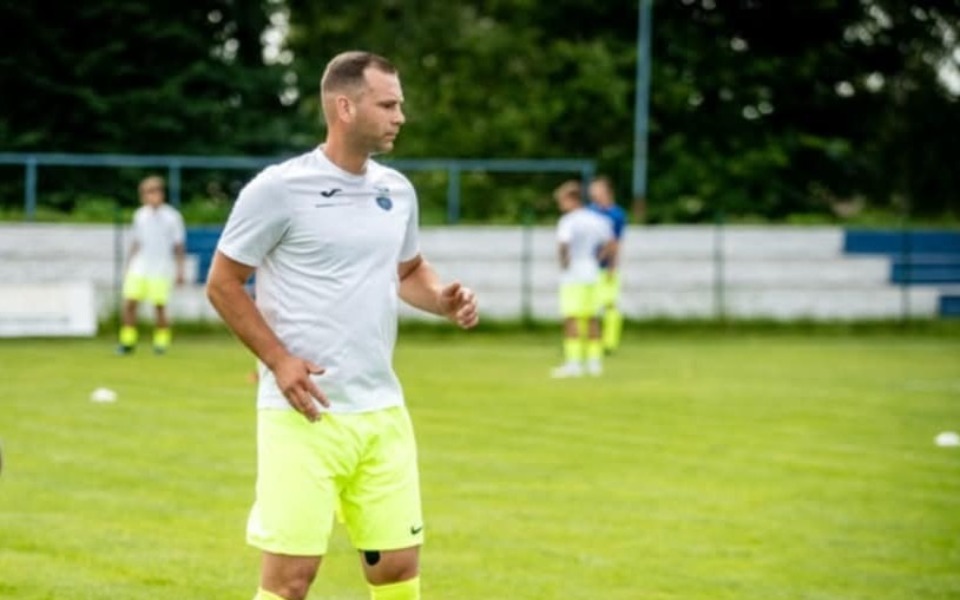 
        Mężczyzna na boisku piłkarskim, przygotowujący się do treningu.
    