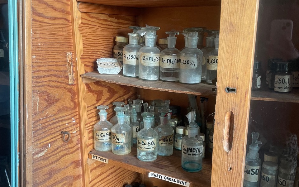 
        Zabytkowe butelki w szafce, pełne tajemnic.
    