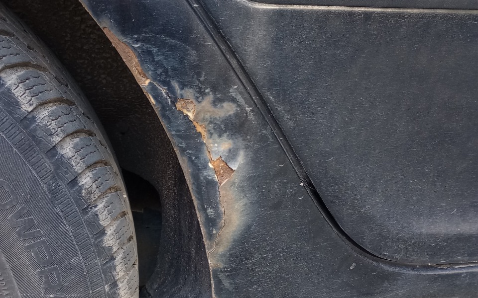 
        Zbliżenie na uszkodzenie karoserii samochodu.
    