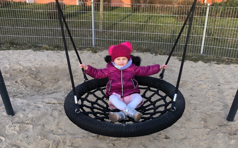 
        Dziecko bawiące się na huśtawce w parku.
    