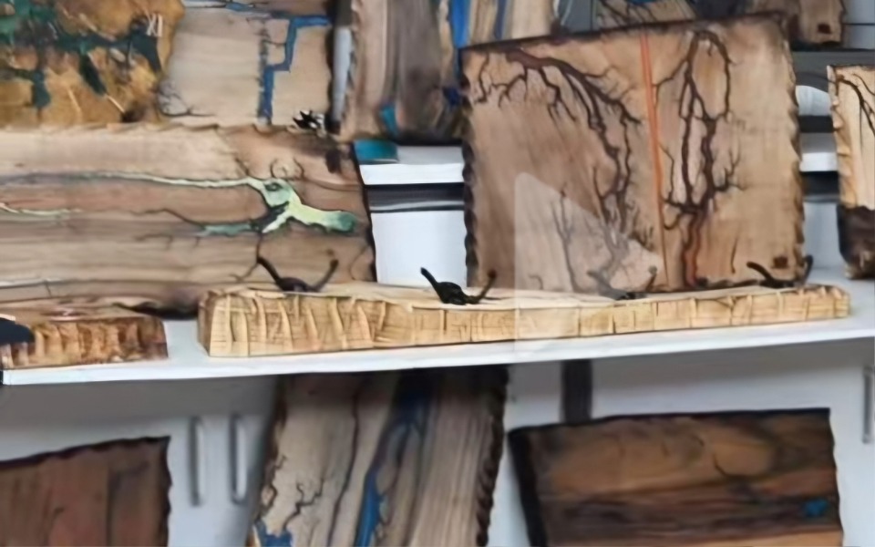 
        Różnorodne drewniane deski na półce.
    