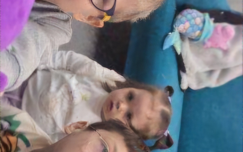 
        Dzieci bawiące się na kanapie, z uśmiechami na twarzach.
    