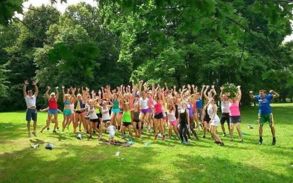 
        Grupa ludzi w sportowych strojach cieszy się na świeżym powietrzu.
    