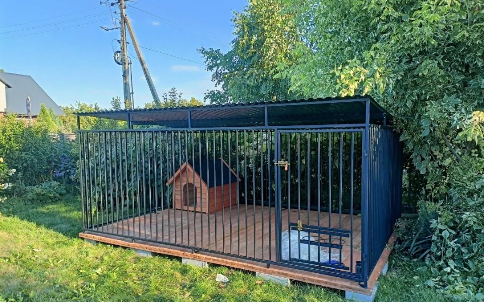 Zadaszone miejsce dla psa w ogrodzie, z budą.