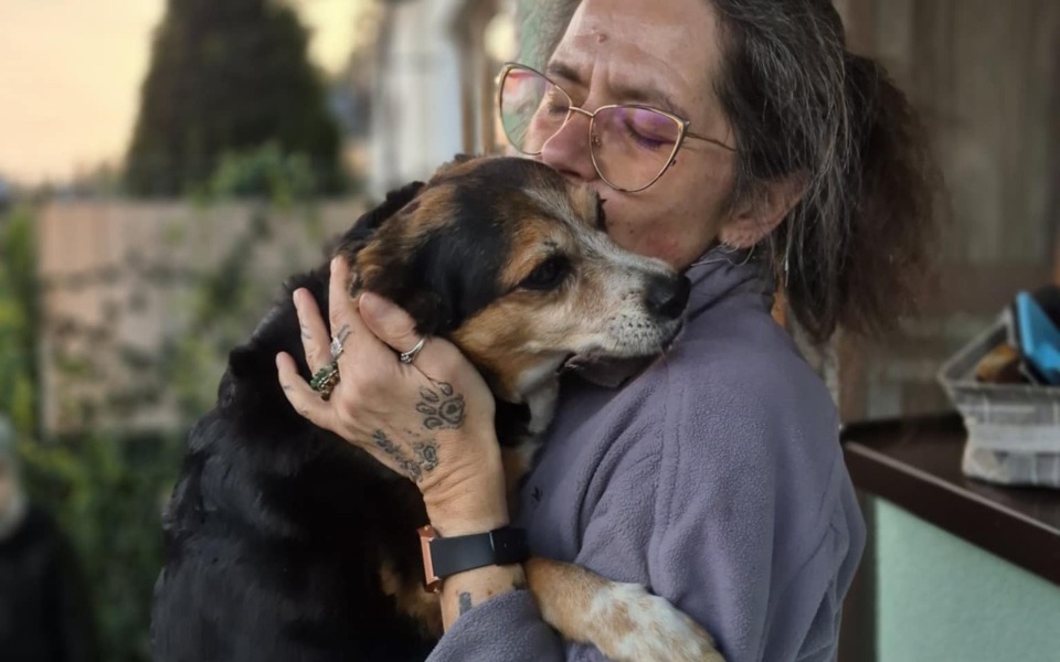 
        Kobieta przytulająca psa, wyrażająca miłość i troskę.
    