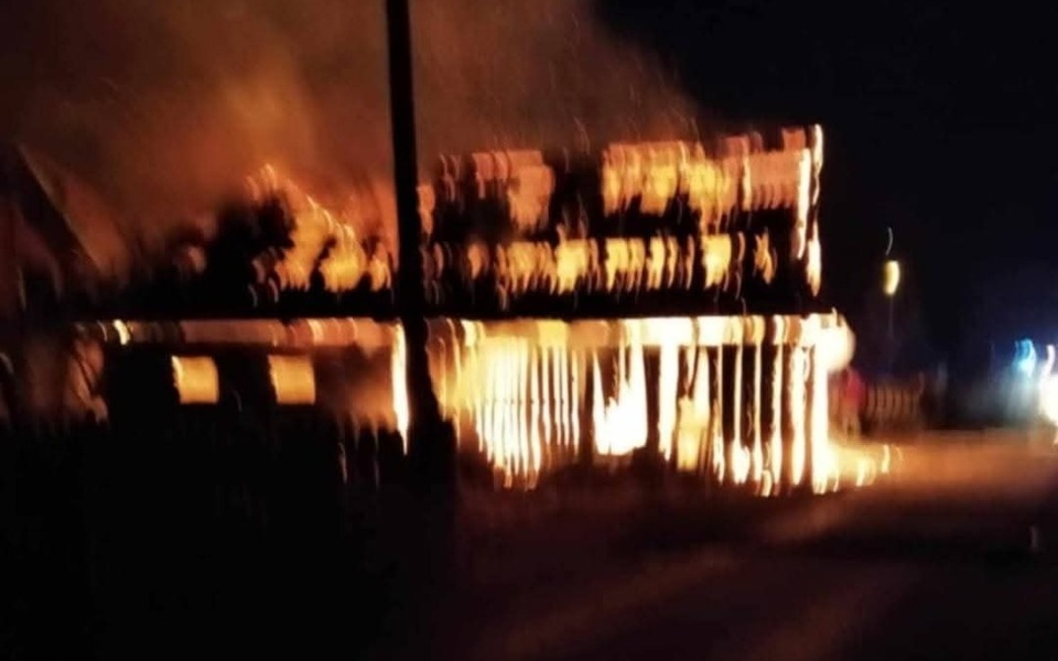 
        Płonący budynek w nocy, ogień otacza konstrukcję.
    