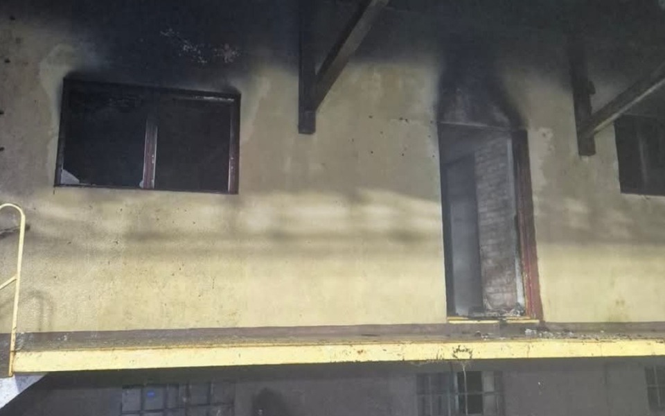 
        Zniszczony budynek po pożarze, z czarnymi śladami.
    