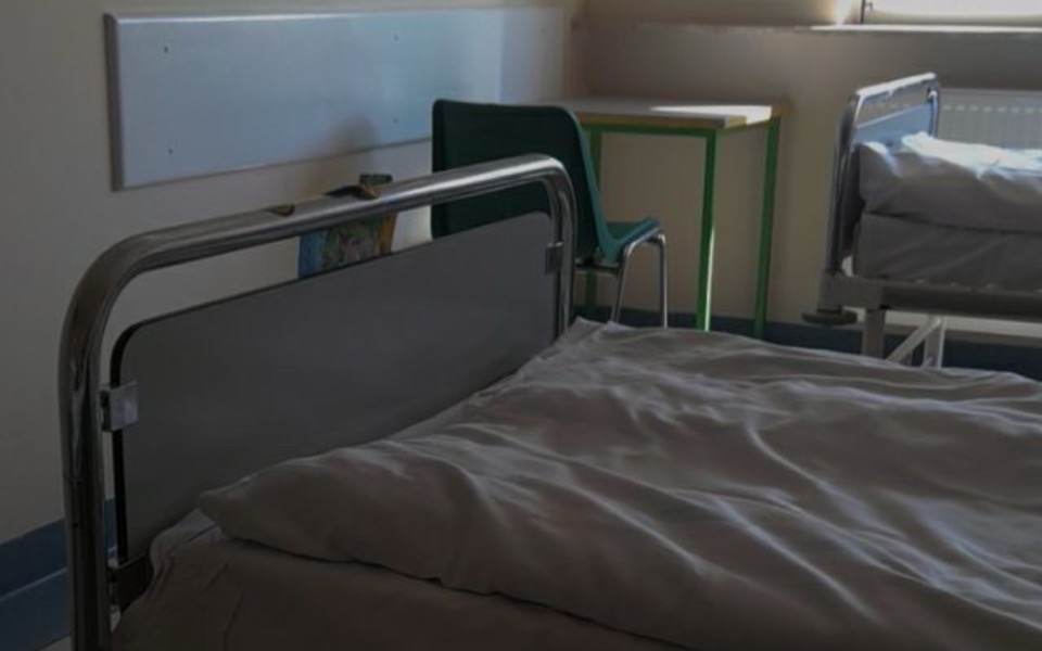
        Pusty pokój szpitalny z łóżkami i biurkiem.
    