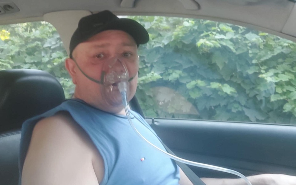 
        Mężczyzna w samochodzie z tlenem na twarzy.
    