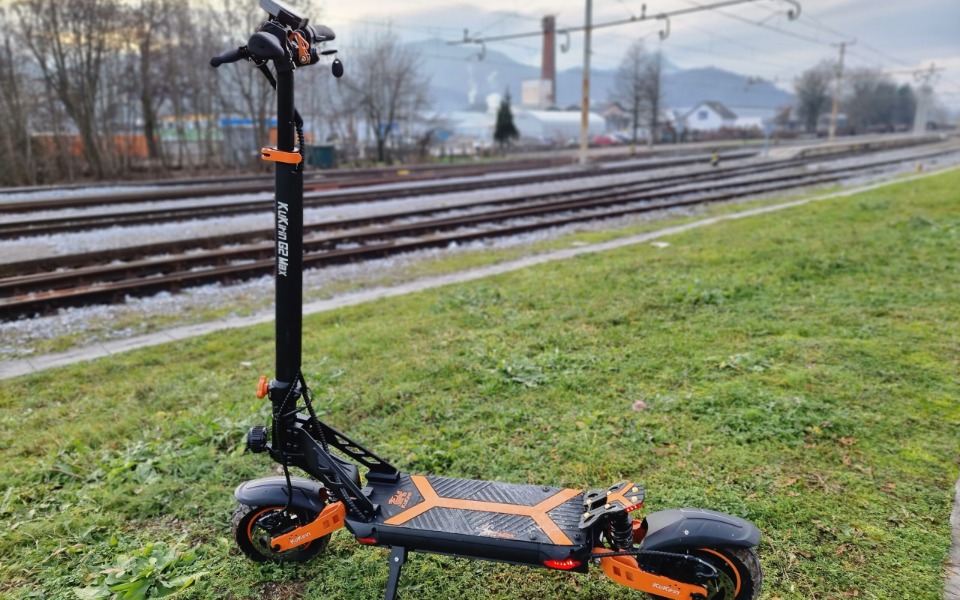 
        Nowoczesna hulajnoga elektryczna na tle torów kolejowych.
    