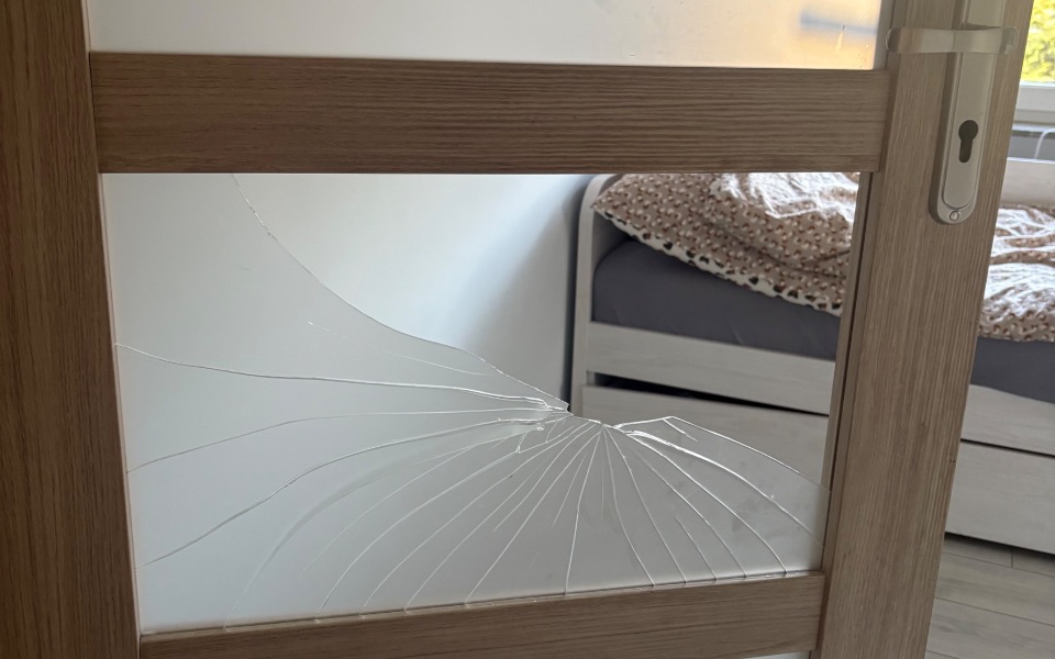 
        Złamane szkło w drzwiach, które wymaga naprawy.
    