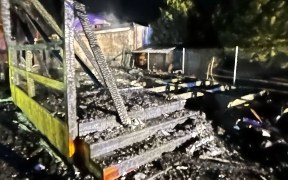 
        Zniszczona konstrukcja po pożarze, z popiołem i resztkami.
    