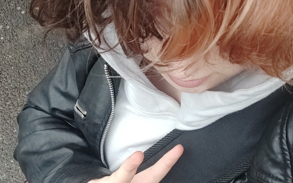 
        Osoba w skórzanej kurtce, robiąca znak pokoju.
    