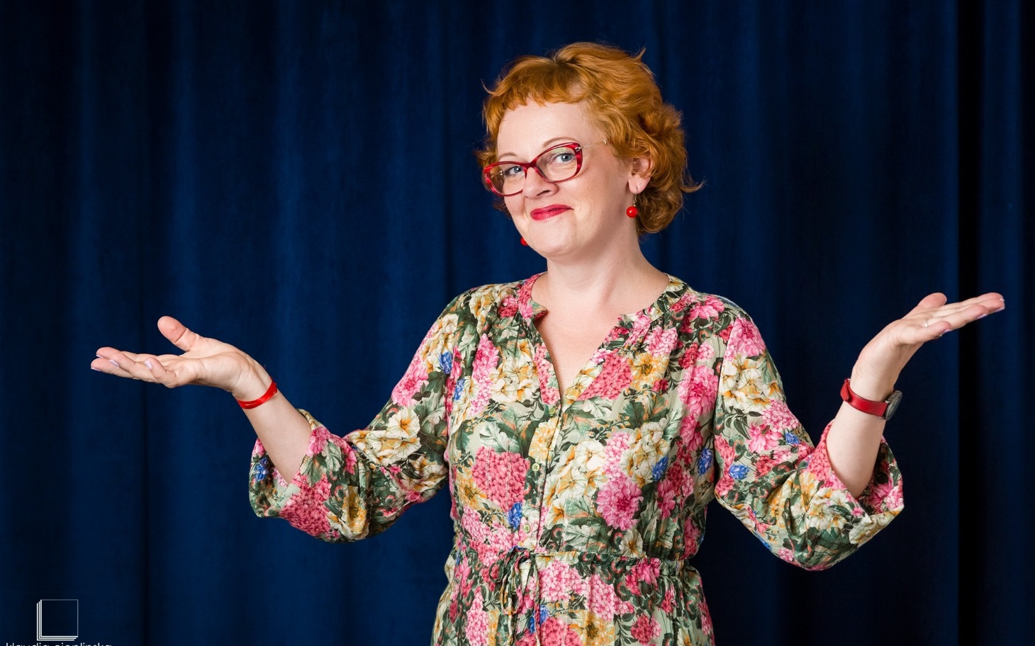 
        Kobieta w kolorowej sukience z uśmiechem.
    