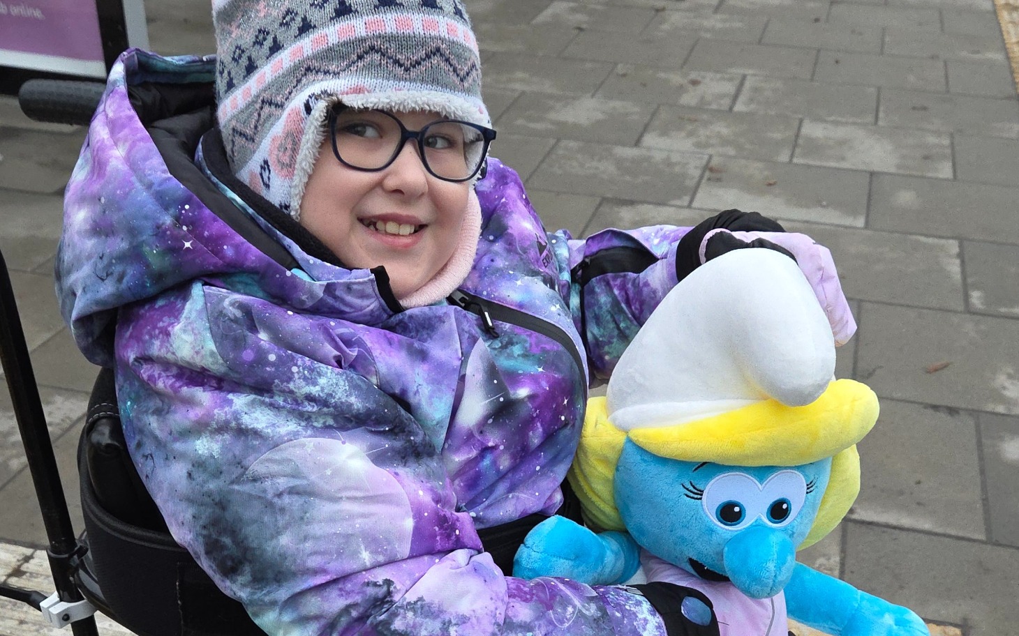 
        Dziewczynka w wózku z pluszowym stworkiem.
    