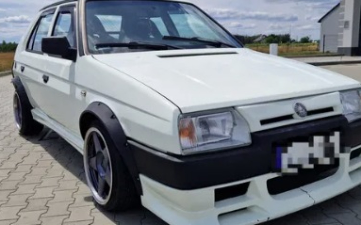 
        Biały samochód osobowy z charakterystycznym wyglądem.
    