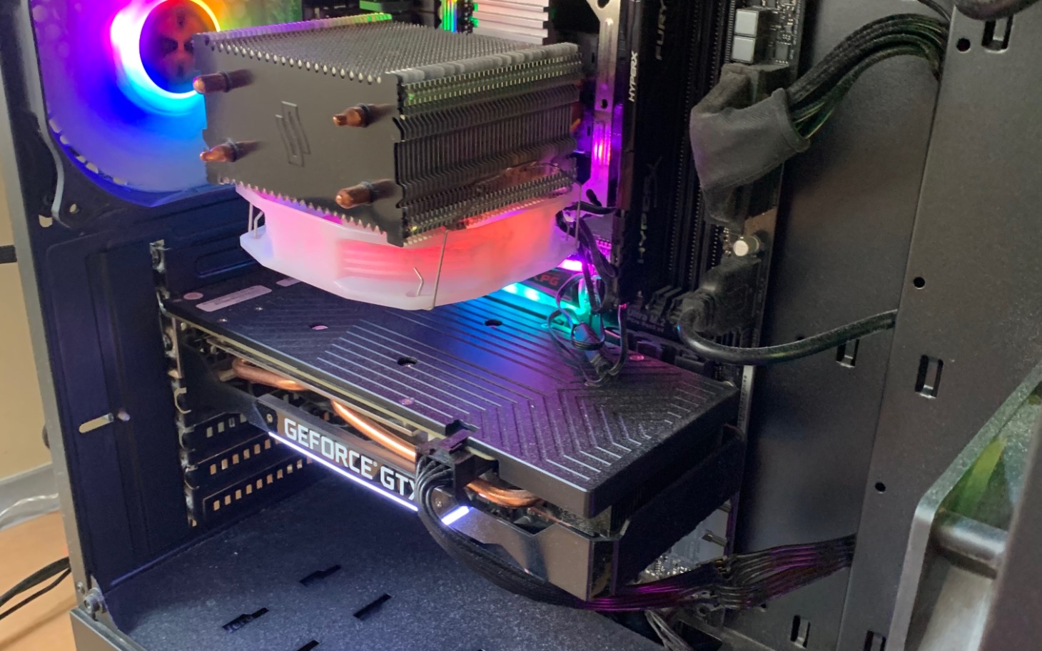 
        Wnętrze komputera z podzespołami i kolorowym podświetleniem.
    