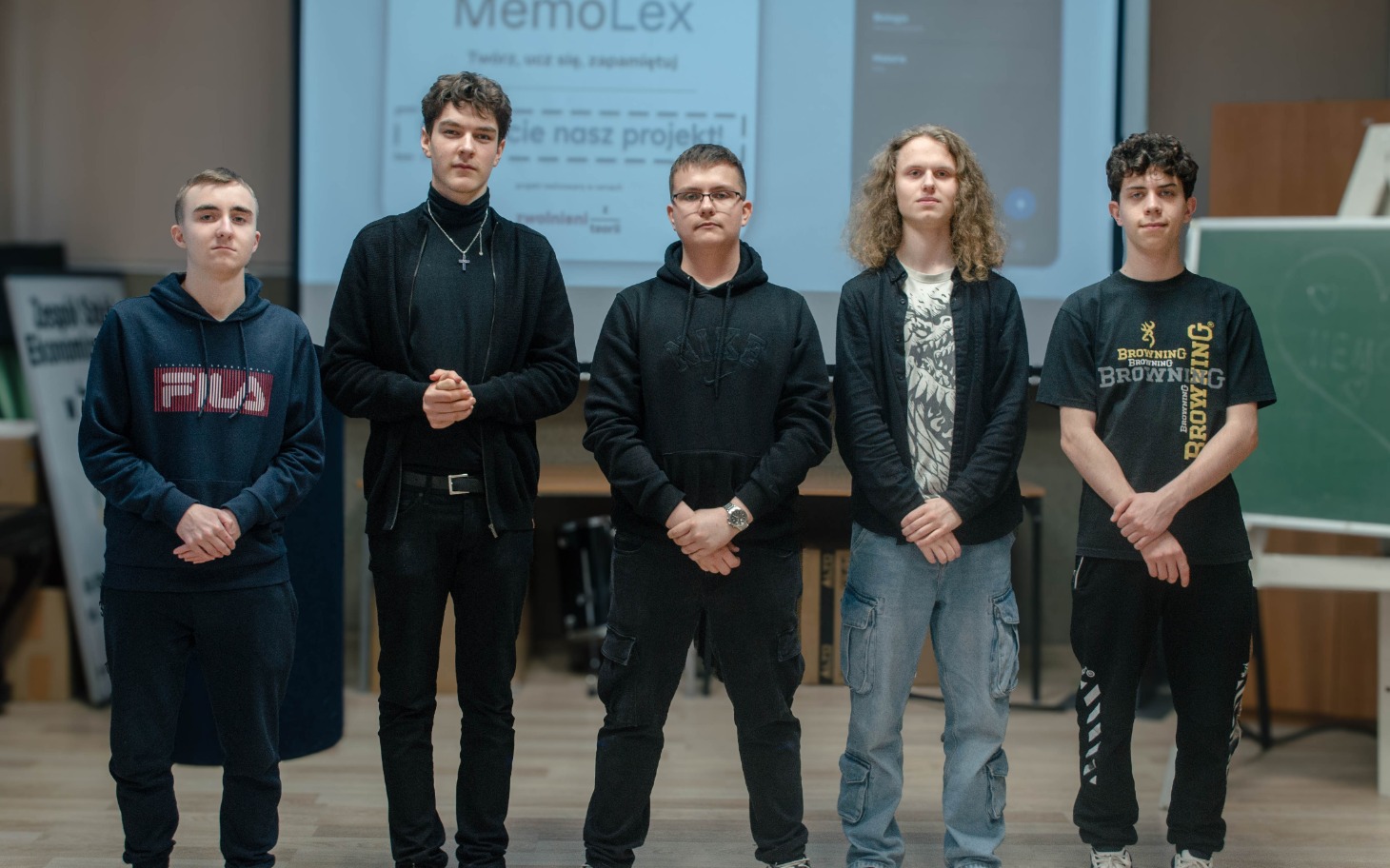 
        Grupa młodych ludzi prezentujących projekt w sali.
    