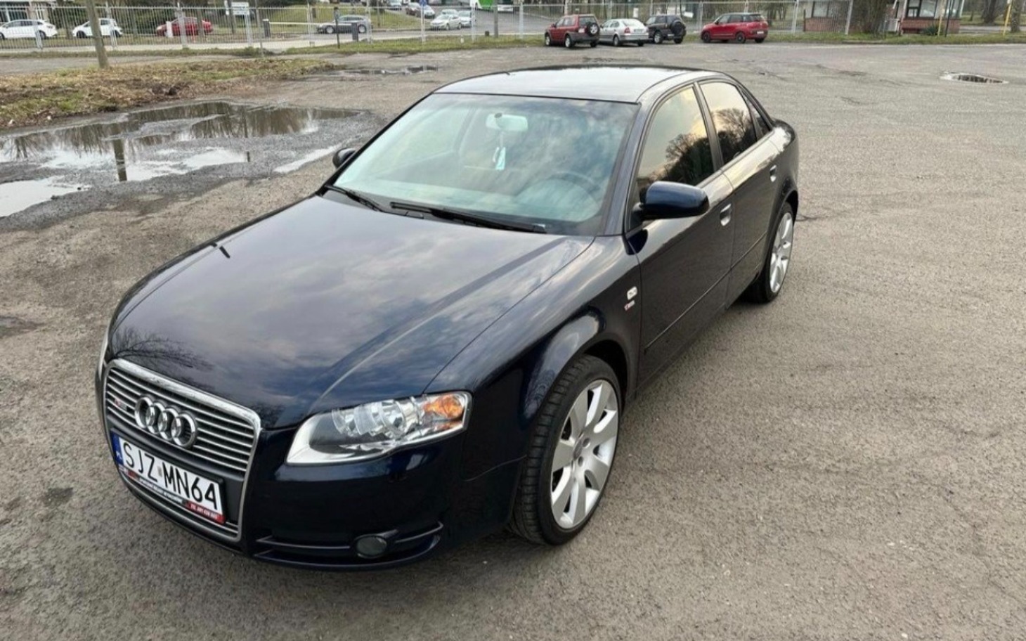 
        Czarny samochód osobowy zaparkowany na parkingu.
    