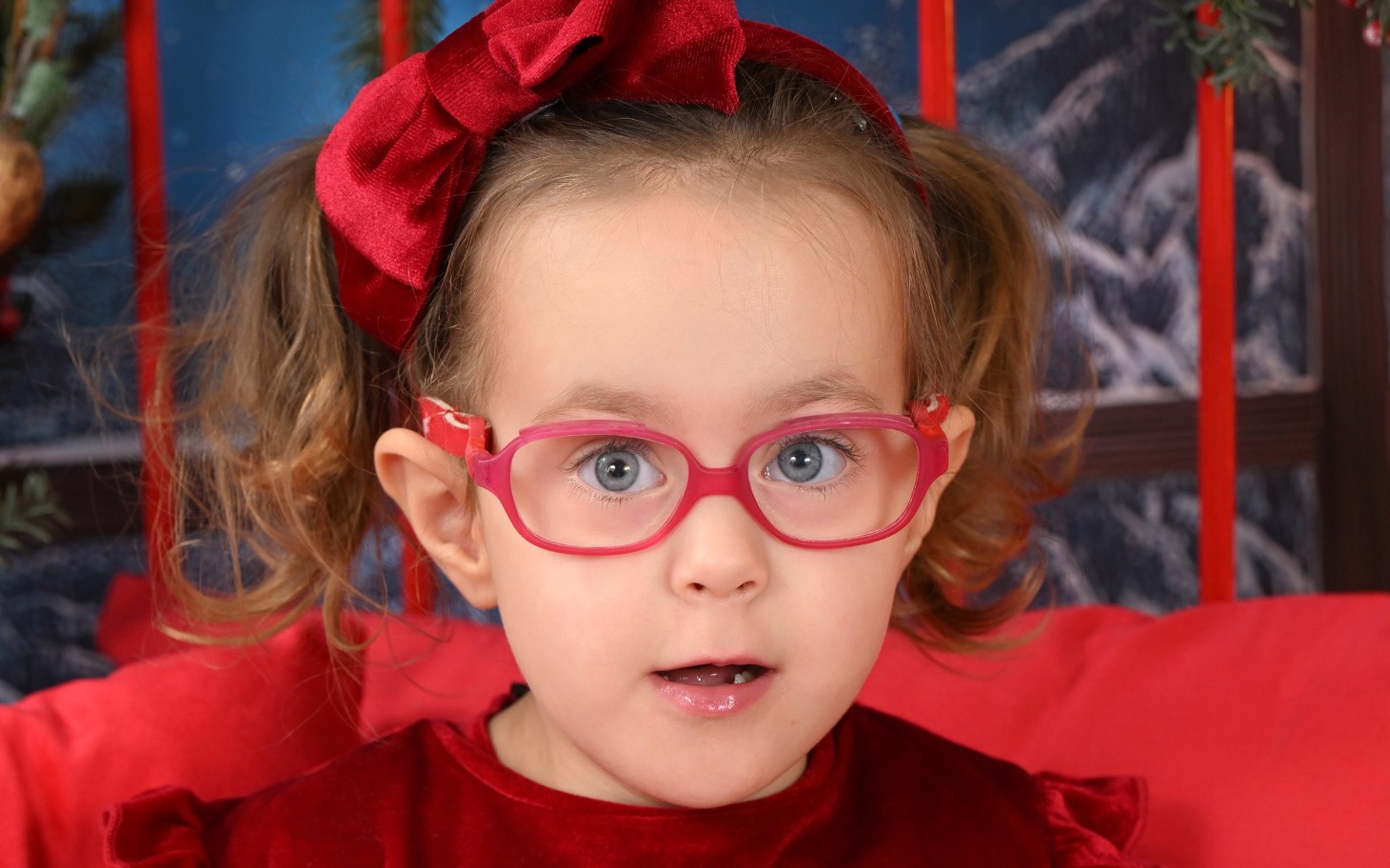 
        Dziewczynka w czerwonej sukience z okularami.
    