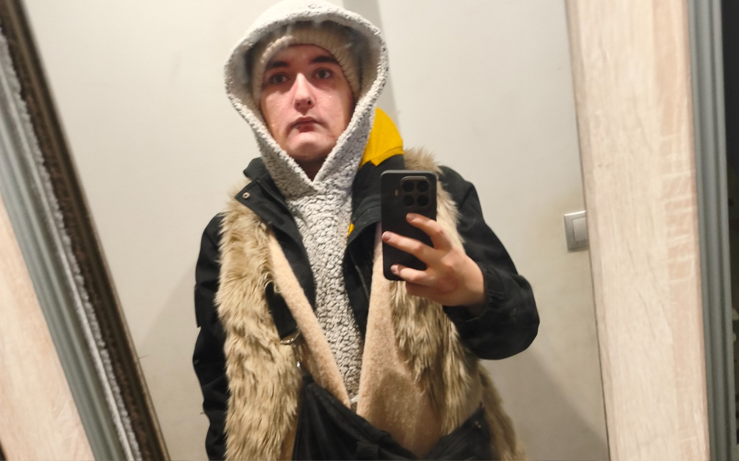 
        Osoba w lustrze, ubrana w ciepłe ubrania.
    