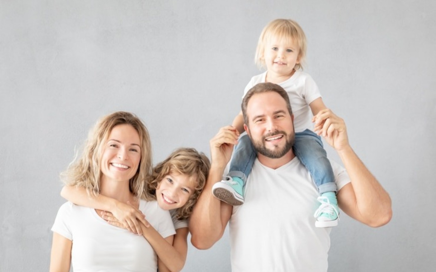 
        Rodzina uśmiechająca się do kamery, spędzająca czas razem.
    