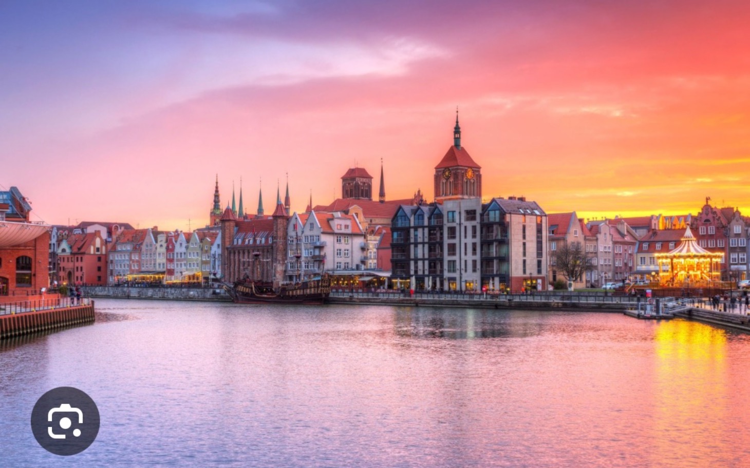 
        Widok na Gdańsk o zachodzie słońca nad rzeką.
    