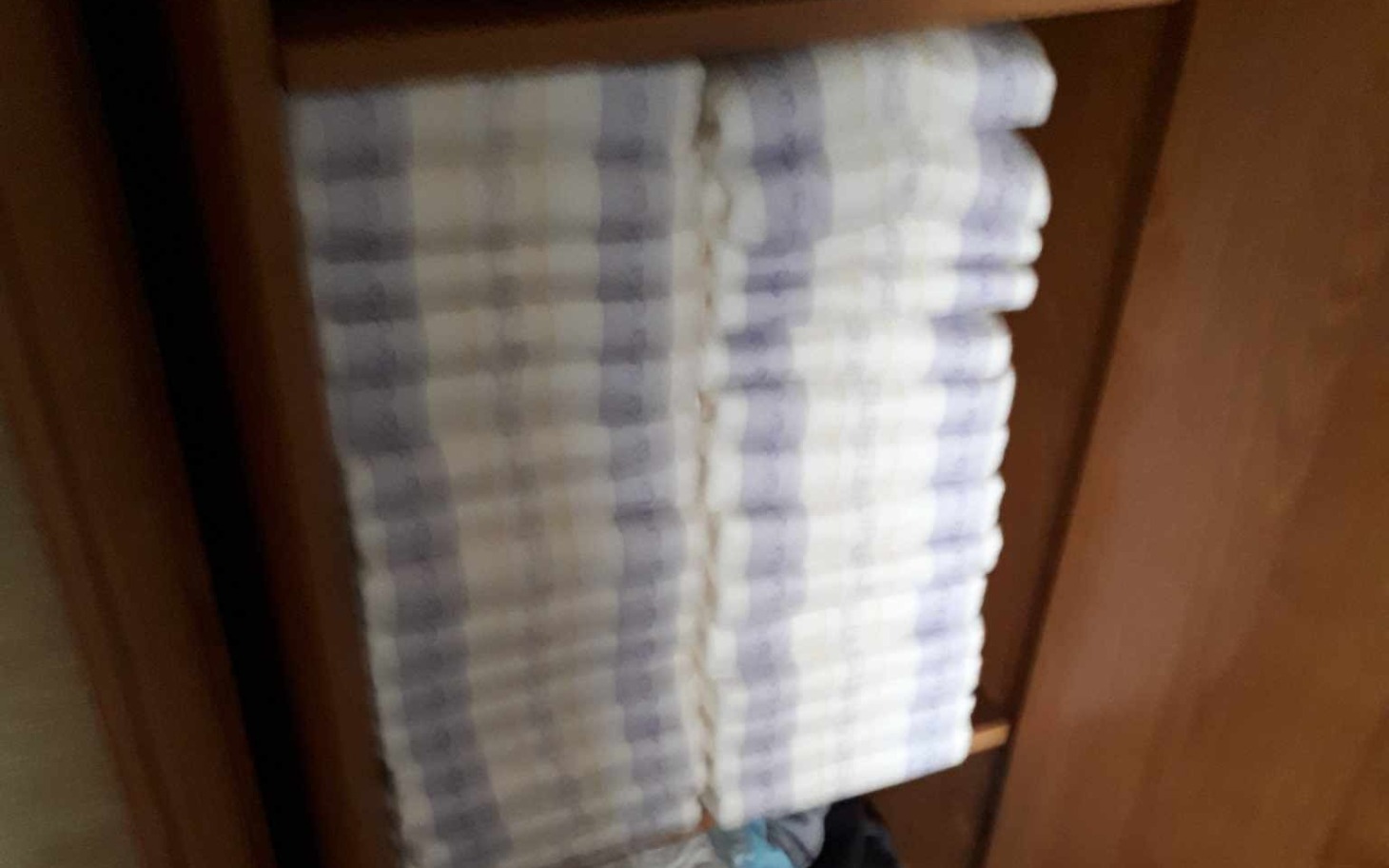 
        Starannie ułożone ręczniki w szafce, porządek w domu.
    