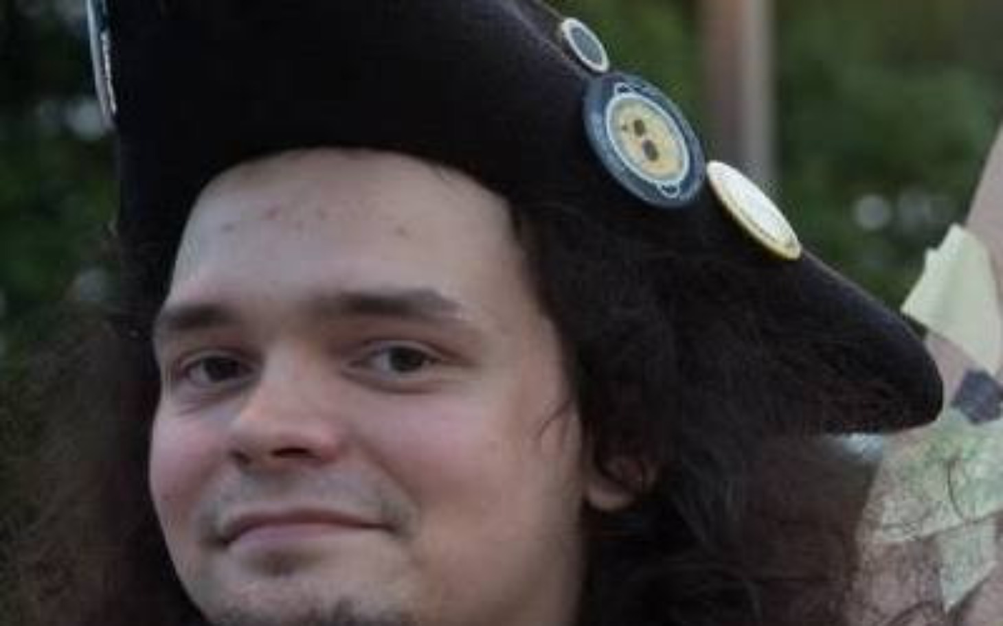 
        Mężczyzna w kapeluszu z uśmiechem na twarzy.
    