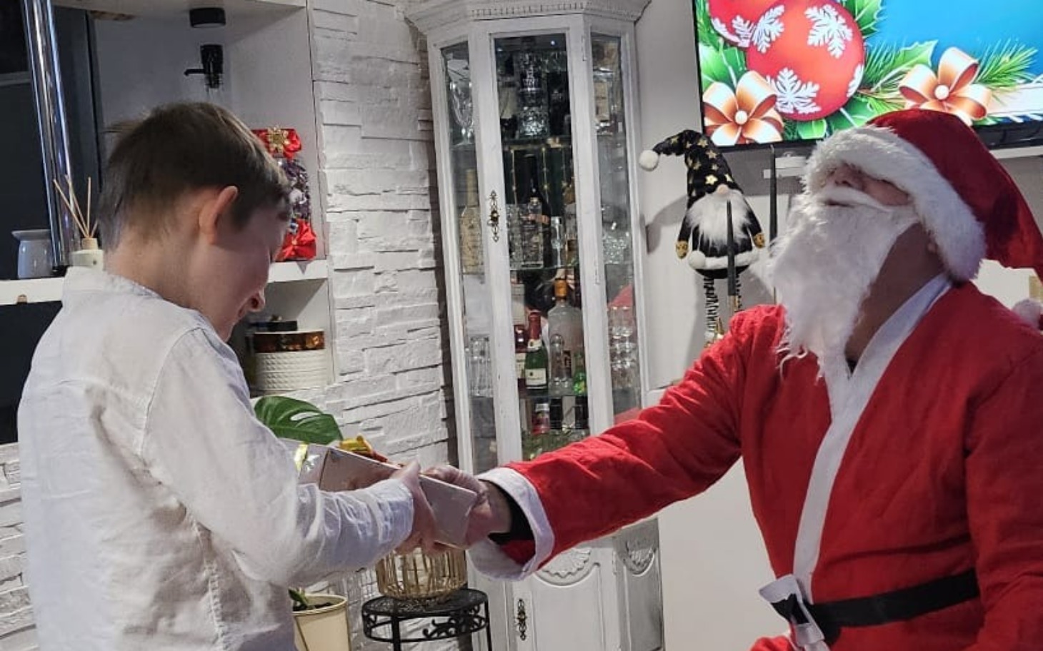 
        Dziecko odbierające prezent od Świętego Mikołaja.
    