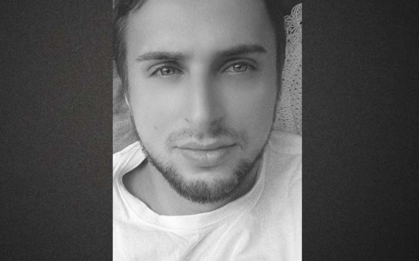 
        Człowiek w czarno-białym selfie, z wyrazem twarzy.
    
