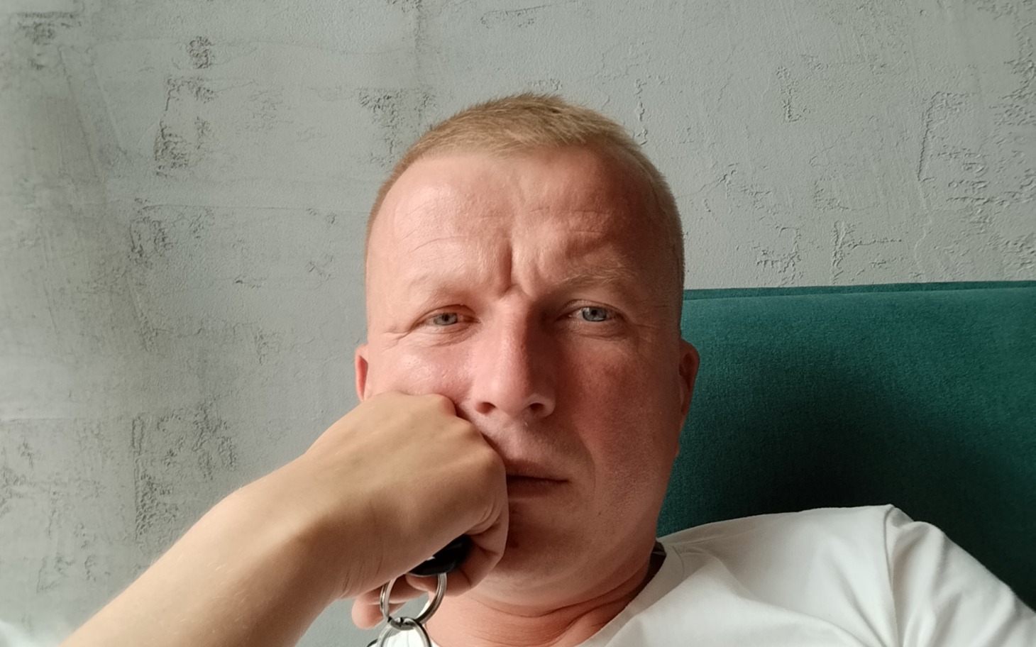 
        Mężczyzna z zamyśloną miną, trzymający rękę przy twarzy.
    