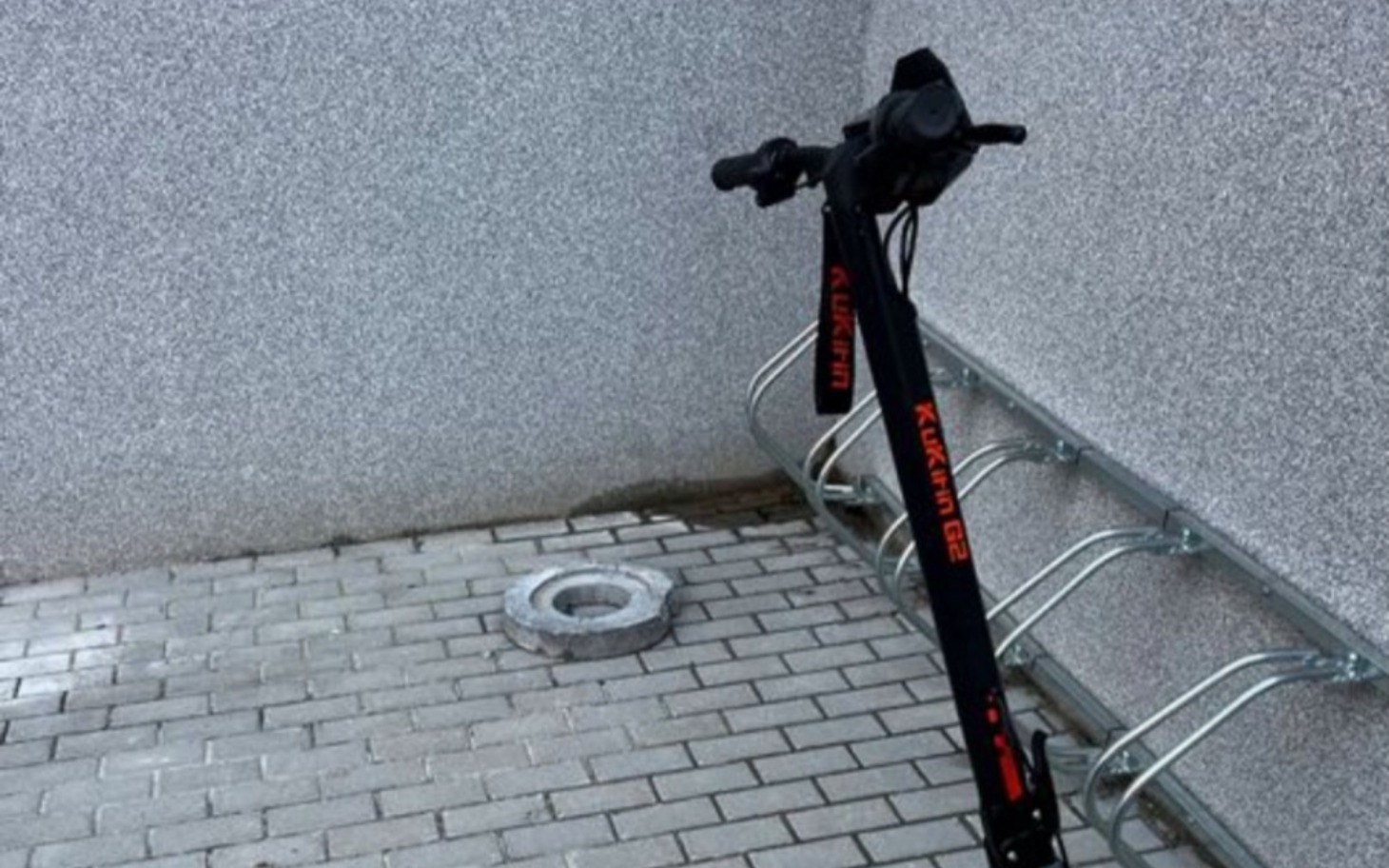 
        Hulajnoga elektryczna zaparkowana przy ścianie.
    