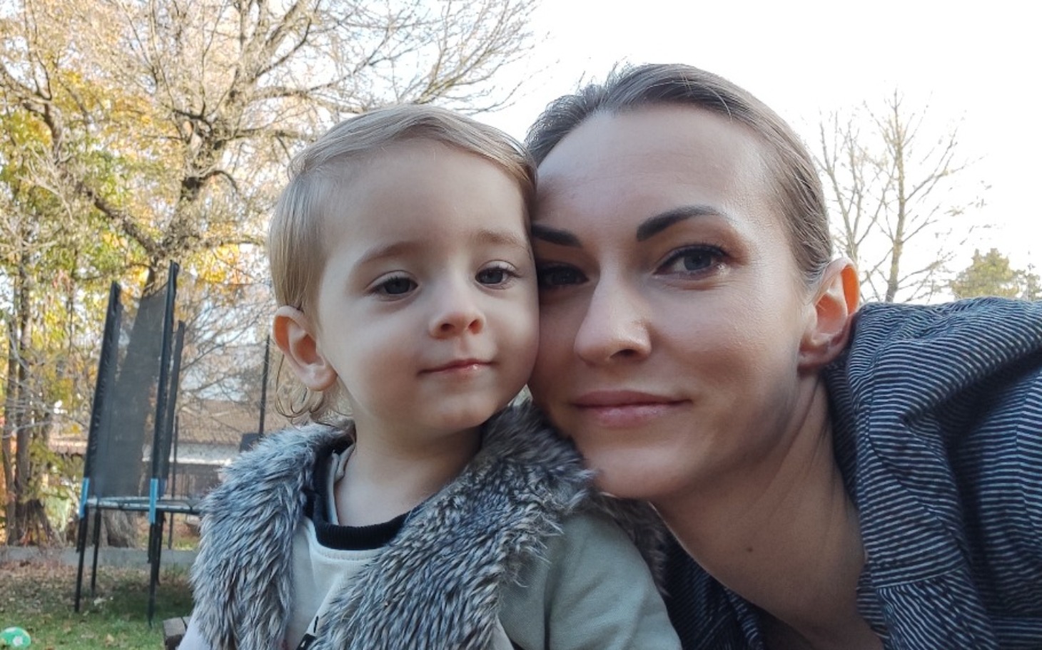 
        Matka z dzieckiem na świeżym powietrzu, uśmiechnięte twarze w słoneczny dzień.
    