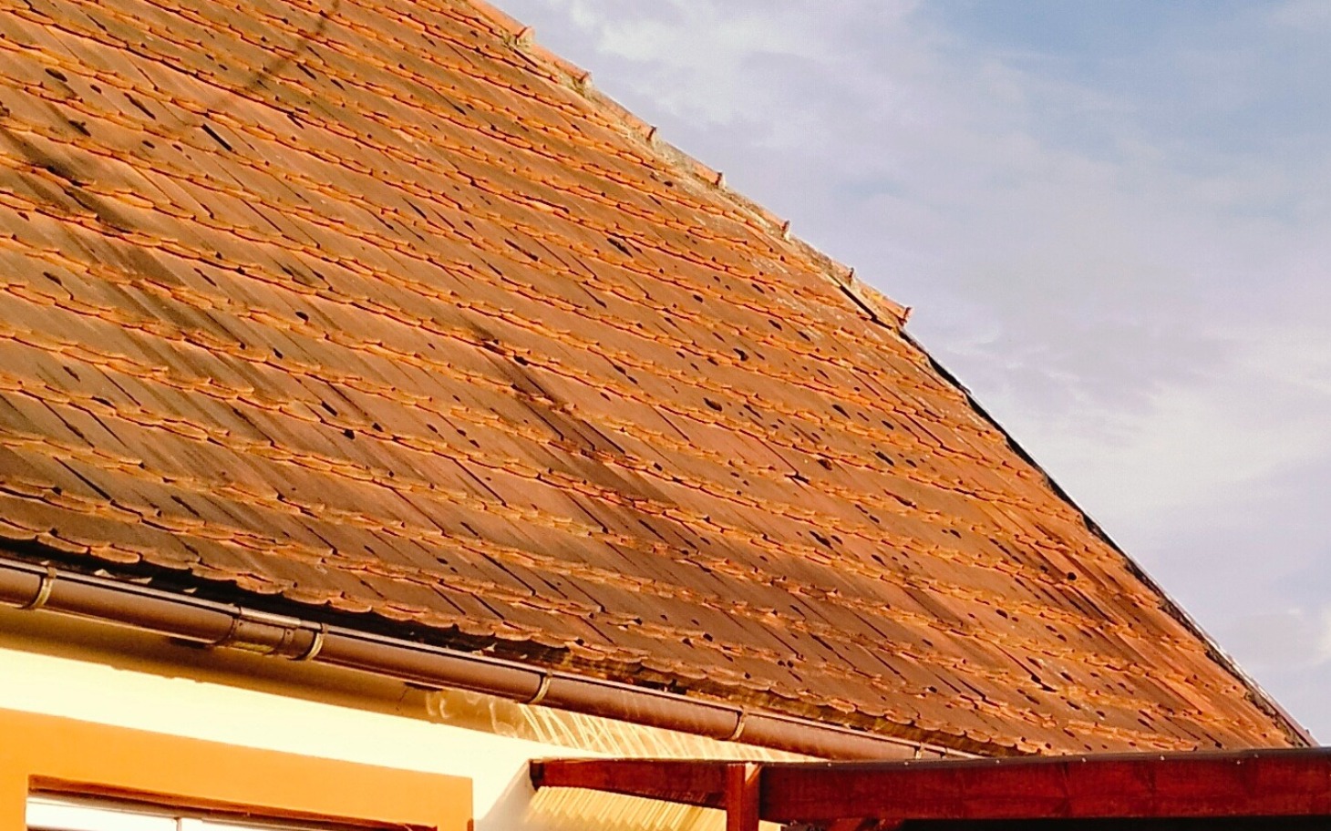 
        Widok na dach domu z ceramicznymi dachówkami.
    