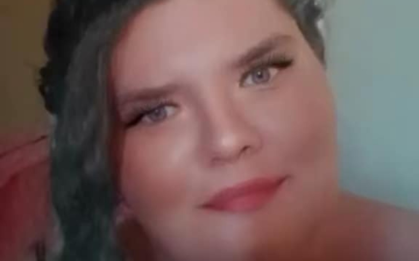 
        Portret kobiety z makijażem, uśmiechającej się do kamery.
    