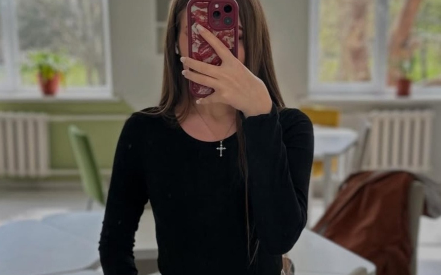 
        Młoda kobieta robiąca selfie w lustrze, w casualowym stroju.
    