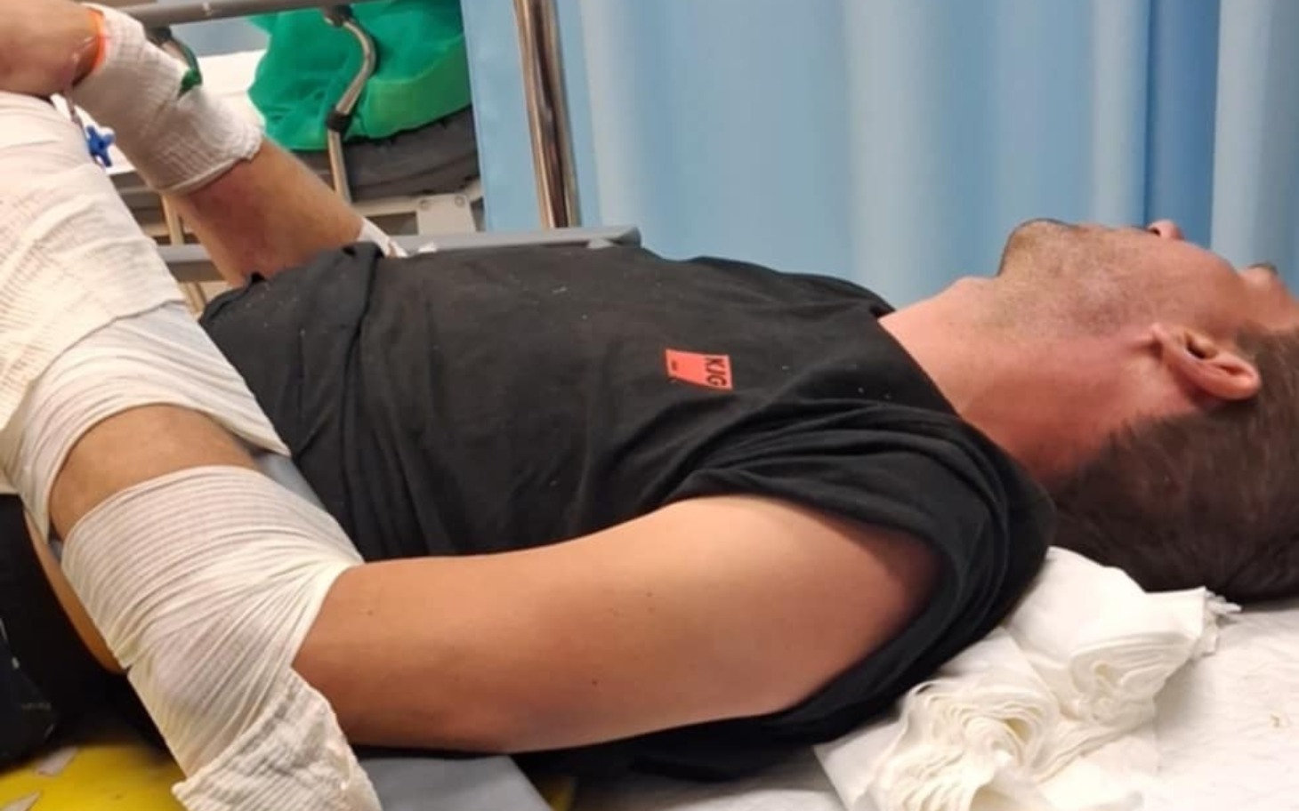 
        Mężczyzna w szpitalu, leżący z opatrunkiem na ręce.
    