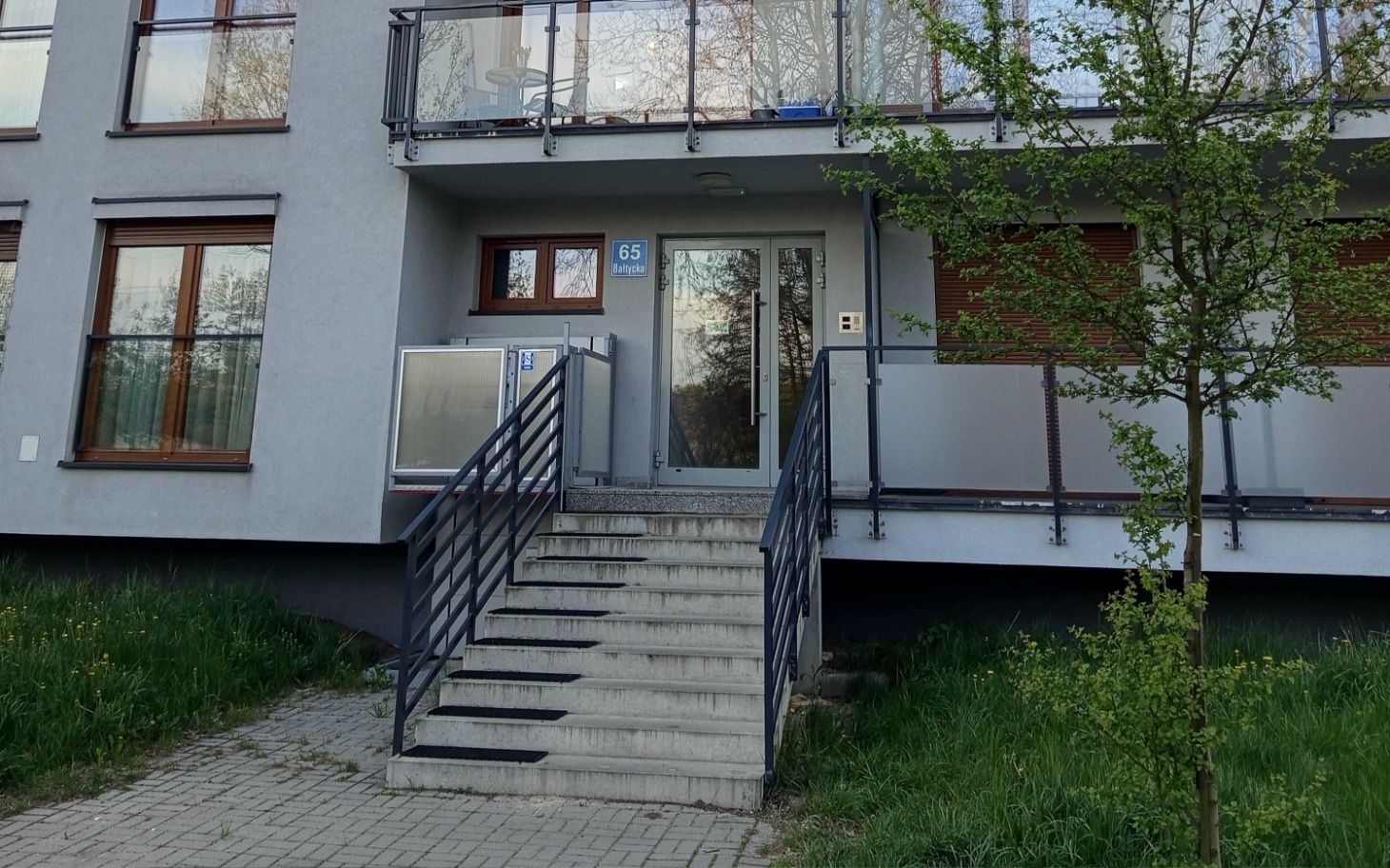 
        Wejście do nowoczesnego budynku mieszkalnego z schodami.
    