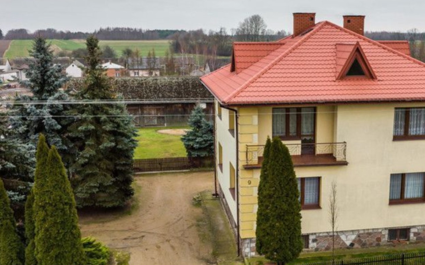 
        Widok na dom z ogrodem w spokojnej okolicy.
    