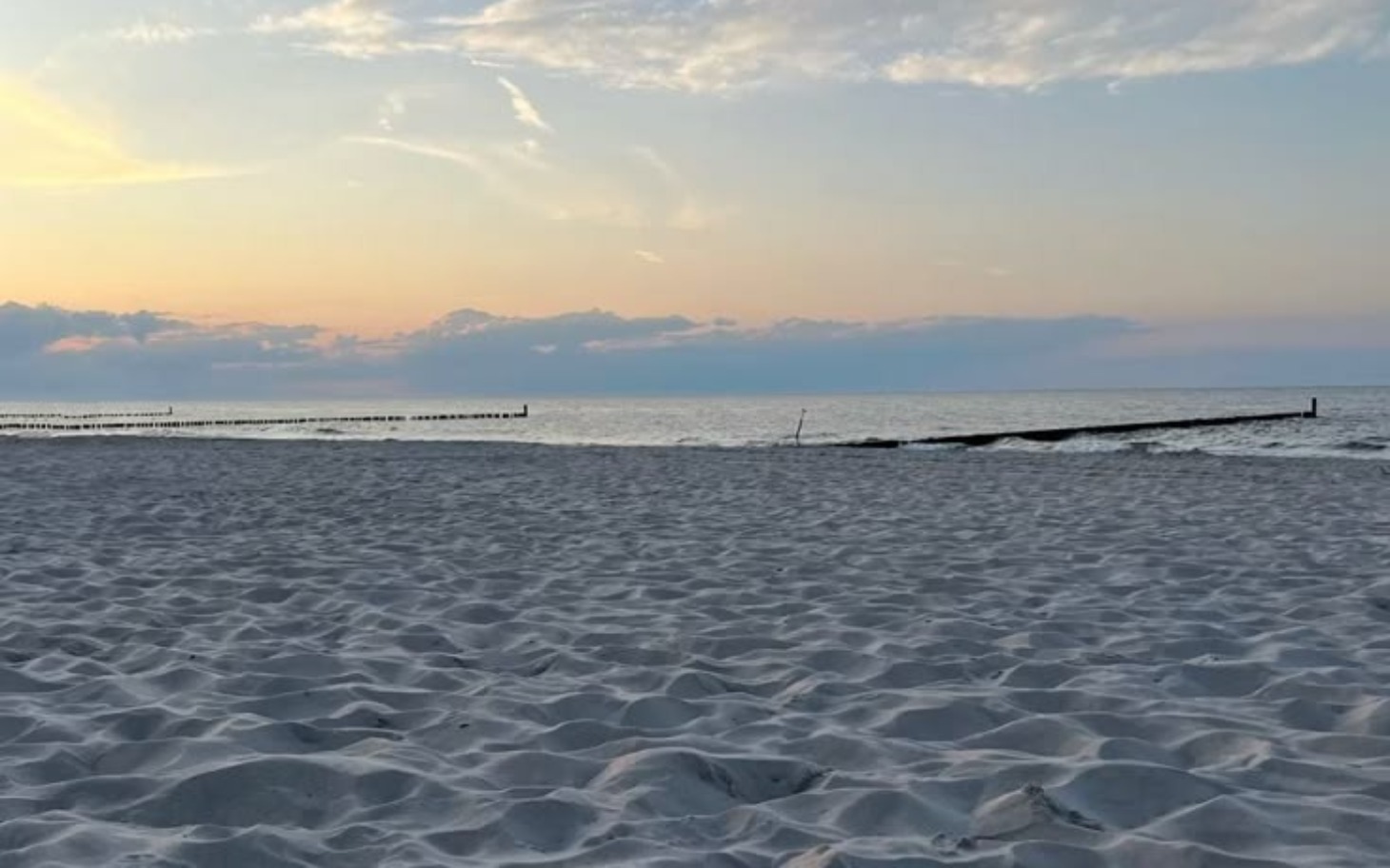 
        Widok na plażę o zachodzie słońca.
    