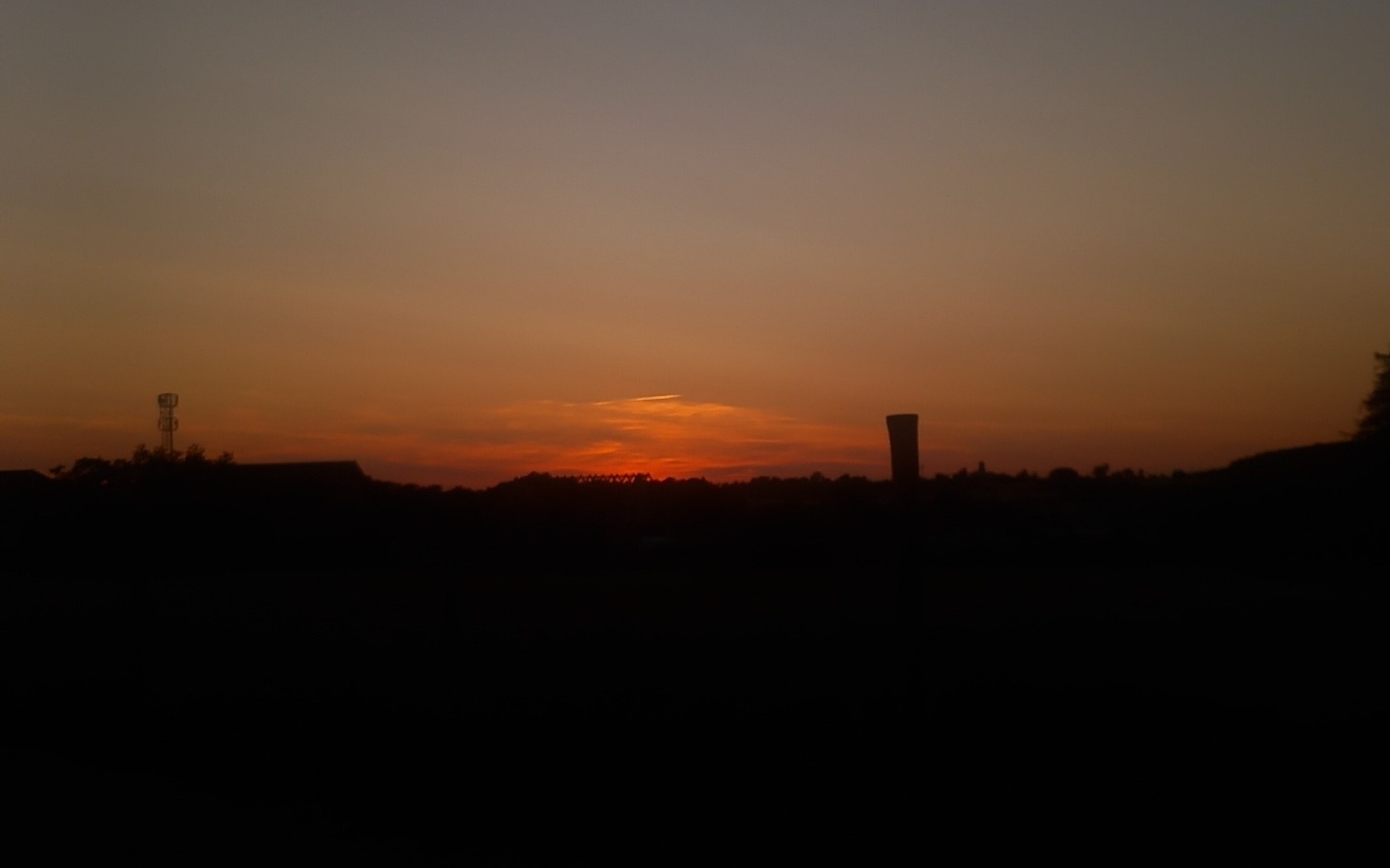 
        Zachód słońca nad horyzontem, z ciepłymi odcieniami nieba.
    