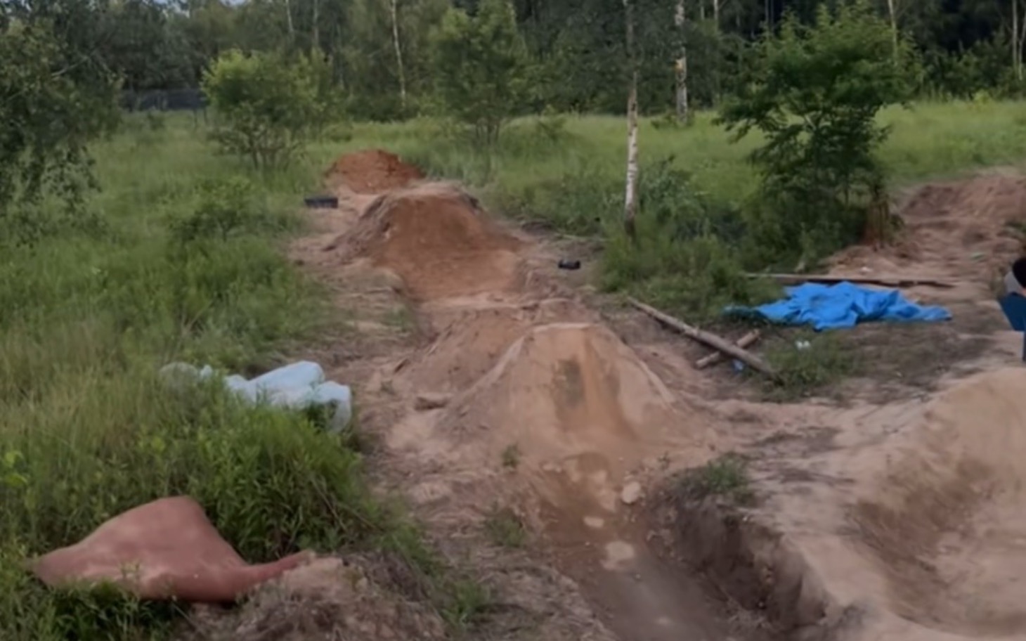 
        Widok na teren z wykopami i przeszkodami do jazdy na rowerze.
    