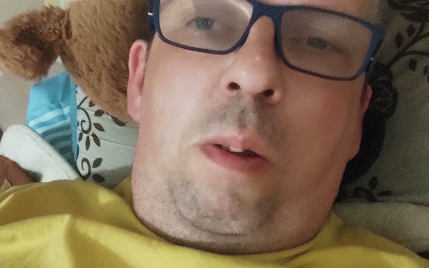
        Mężczyzna leżący na łóżku, selfie z bliskiej odległości.
    
