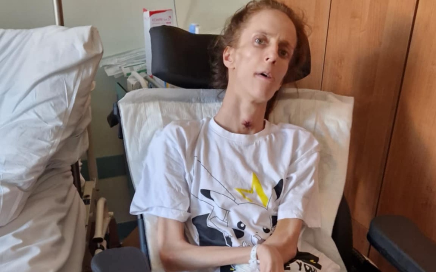 
        Osoba w szpitalu, wyglądająca na osłabioną.
    